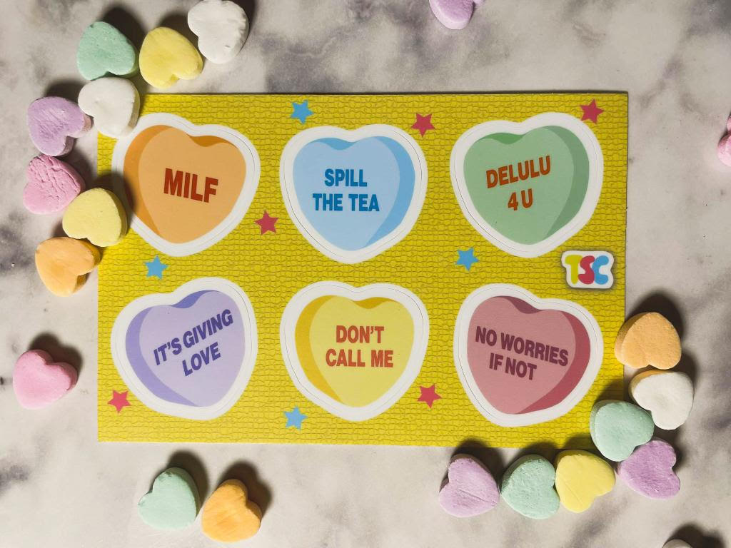 Sticker sheet of conversation hearts, each a different color: orange, blue, green, purple, yellow, and pink. They read MILF, spill the tea, delulu for you, it's giving love, don't call me, and no worries if not.